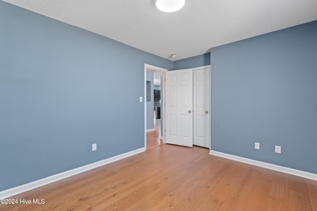 unfurnished bedroom featuring light hardwood / wood-style floors and a textured ceiling