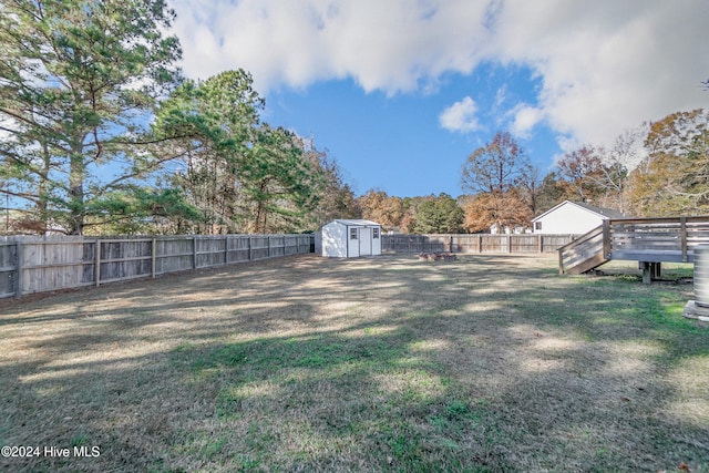 view of yard featuring a storage shed and a wooden deck