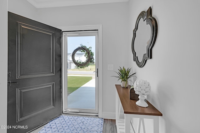 foyer with crown molding and hardwood / wood-style flooring