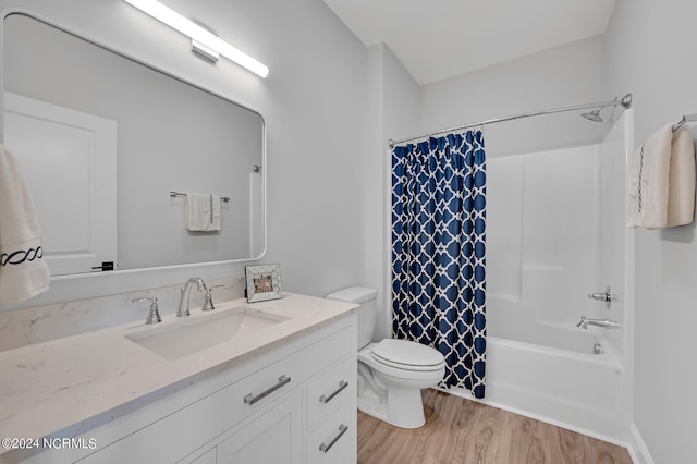 full bathroom with shower / bathtub combination with curtain, toilet, hardwood / wood-style flooring, and vanity