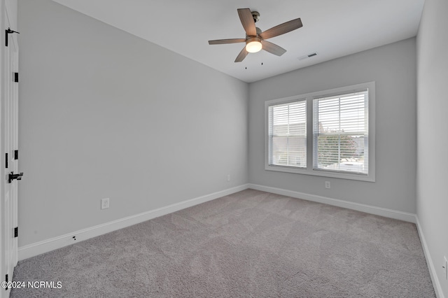 empty room featuring ceiling fan and light colored carpet