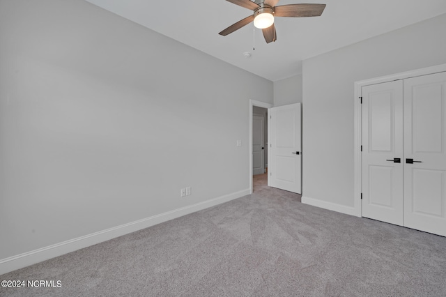 unfurnished bedroom featuring a closet, ceiling fan, and light colored carpet