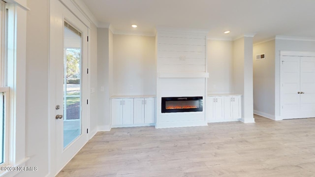 2090 Greenside Manor Dr Unit L-39, Ocean Isle Beach, NC 28469 - unfurnished living room with ornamental molding, light wood-style floors, a glass covered fireplace, and recessed lighting
