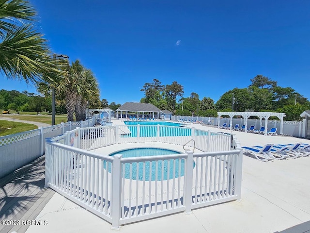 2090 Greenside Manor Dr Unit L-39, Ocean Isle Beach, NC 28469 - community pool featuring a pergola, a community hot tub, and view of scattered trees