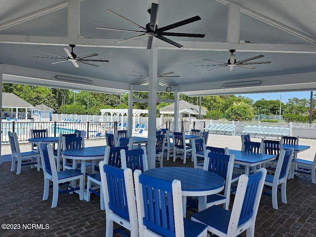 2090 Greenside Manor Dr Unit L-39, Ocean Isle Beach, NC 28469 - view of patio featuring ceiling fan, outdoor dining area, and a community pool