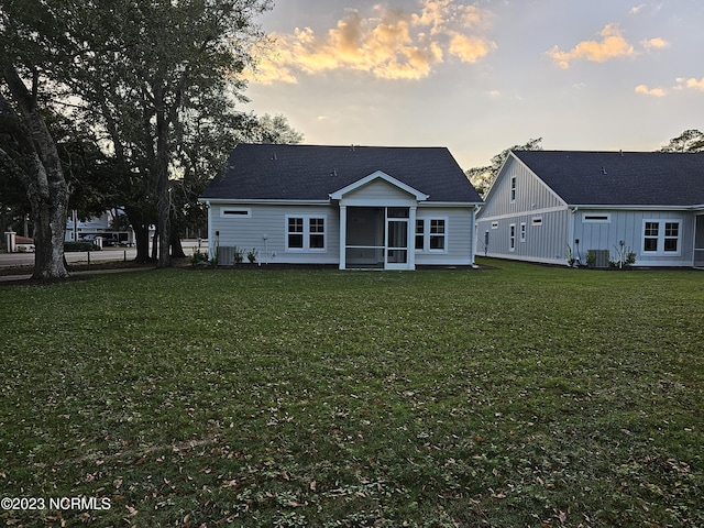 2090 Greenside Manor Dr Unit L-39, Ocean Isle Beach, NC 28469 - back of house at dusk with a sunroom and a yard