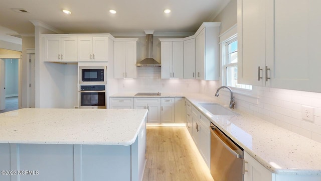 2090 Greenside Manor Dr Unit L-39, Ocean Isle Beach, NC 28469 - kitchen with black appliances, wall chimney exhaust hood, light wood-type flooring, white cabinetry, and ornamental molding