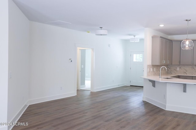 235 Weathersbee Dr, Hampstead, NC 28443 - kitchen with light countertops, decorative backsplash, dark wood-type flooring, gray cabinetry, and a kitchen bar