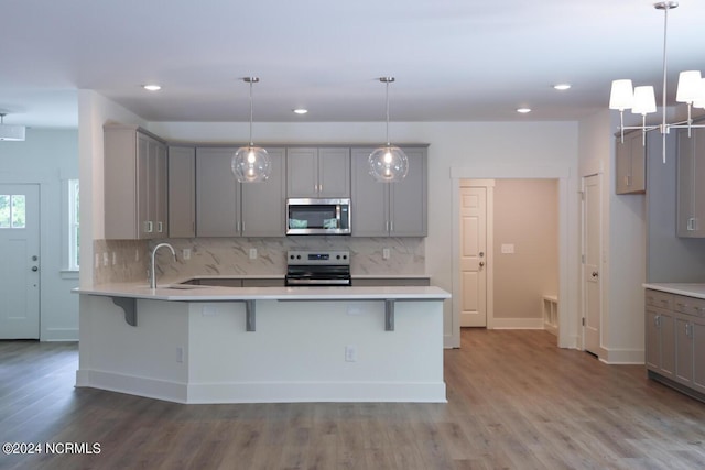235 Weathersbee Dr, Hampstead, NC 28443 - kitchen with a peninsula, tasteful backsplash, a sink, gray cabinetry, and stainless steel appliances