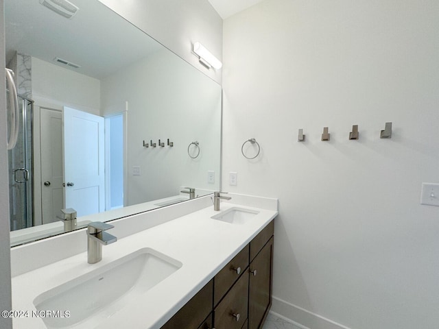 235 Weathersbee Dr, Hampstead, NC 28443 - bathroom featuring a sink, baseboards, double vanity, and visible vents