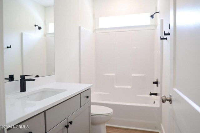 235 Weathersbee Dr, Hampstead, NC 28443 - bathroom with vanity, washtub / shower combination, wood finished floors, and toilet