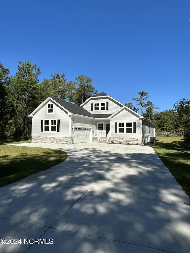 235 Weathersbee Dr, Hampstead, NC 28443 - bungalow-style house with an attached garage, a front lawn, stone siding, and concrete driveway