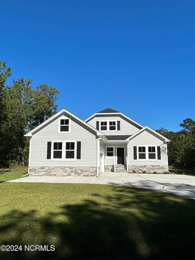 235 Weathersbee Dr, Hampstead, NC 28443 - rear view of house featuring a lawn and stone siding