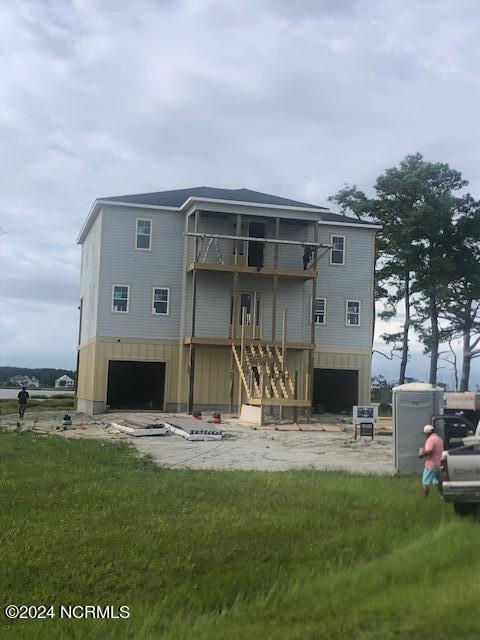 rear view of house featuring a yard and a balcony