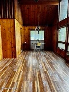 unfurnished living room with dark wood-type flooring and wood walls