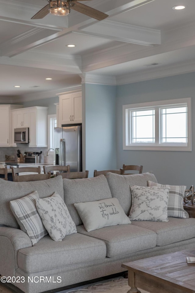 living room featuring coffered ceiling, ceiling fan, crown molding, and beam ceiling