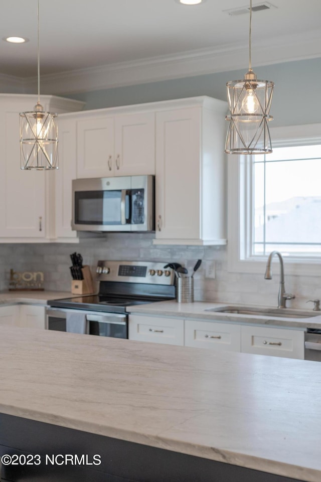 kitchen with white cabinets, backsplash, sink, and stainless steel appliances