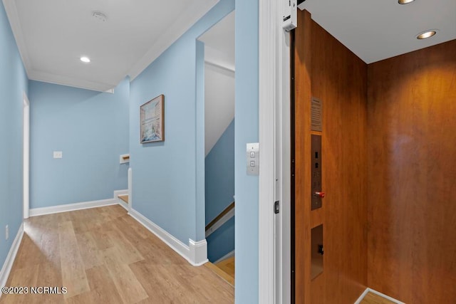 hallway with light hardwood / wood-style flooring and elevator