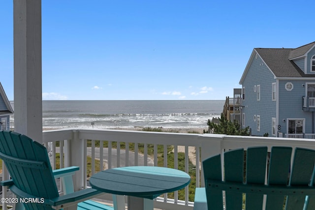 balcony featuring a beach view and a water view