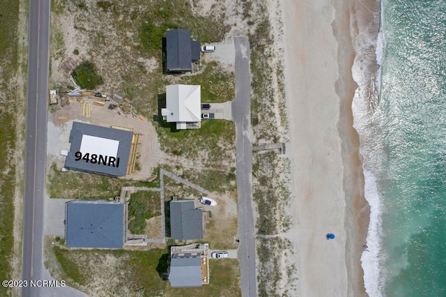 drone / aerial view featuring a beach view and a water view