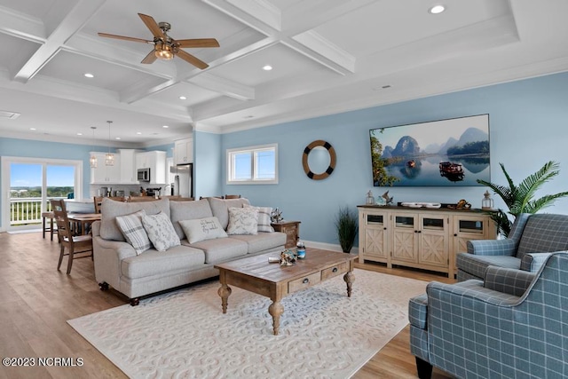 living room featuring ceiling fan, ornamental molding, light hardwood / wood-style floors, coffered ceiling, and beam ceiling