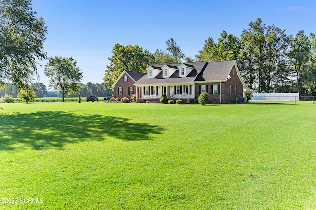 cape cod-style house with a front lawn and a porch