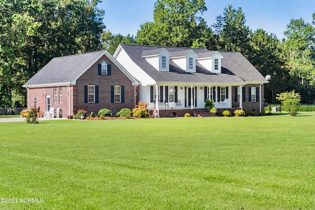 cape cod house featuring a porch and a front yard