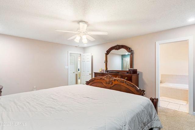 carpeted bedroom with ensuite bath, ceiling fan, and a textured ceiling