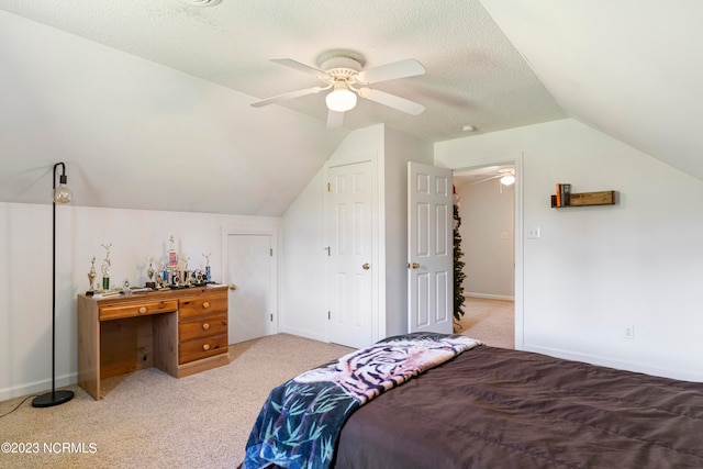 bedroom featuring lofted ceiling, ceiling fan, light carpet, and a textured ceiling