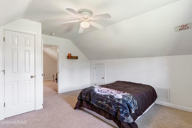 carpeted bedroom with lofted ceiling, ceiling fan, and a textured ceiling