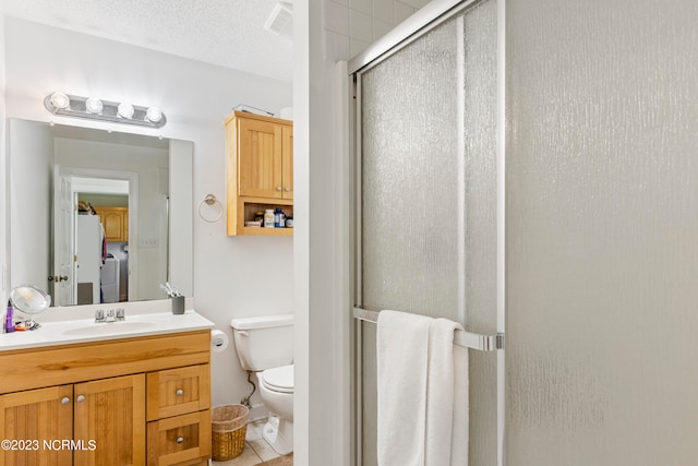 bathroom featuring tile patterned floors, a textured ceiling, vanity, toilet, and a shower with shower door