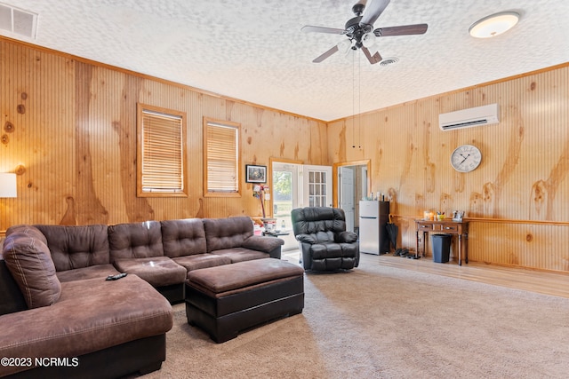 carpeted living room with a wall mounted air conditioner, a textured ceiling, and ceiling fan