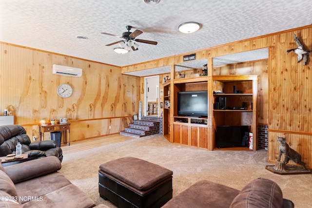 carpeted living room with a wall mounted AC, ceiling fan, wooden walls, and a textured ceiling