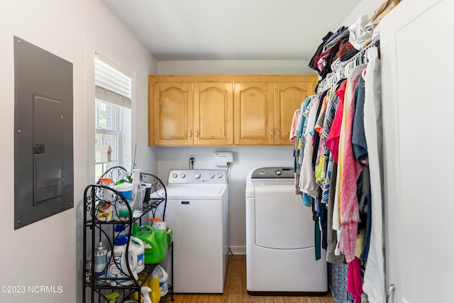 washroom featuring electric panel, cabinets, and washer and dryer