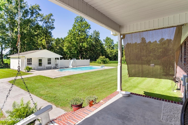 view of yard with an outbuilding, a fenced in pool, and a patio