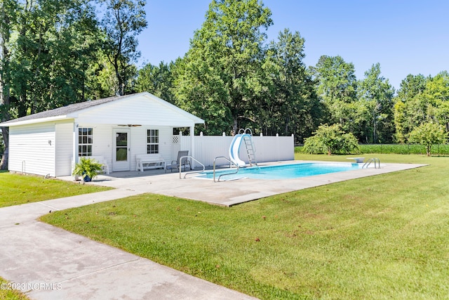 view of pool with a patio, a lawn, a diving board, and a water slide