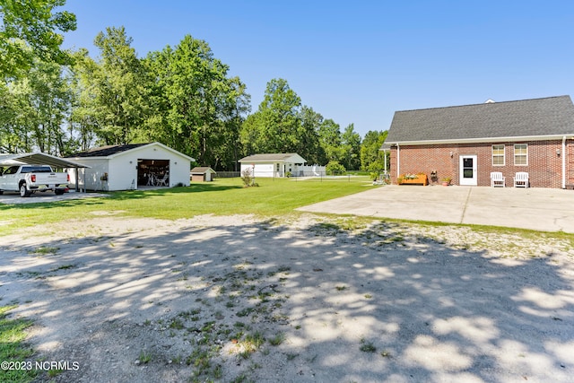 view of yard with a carport and an outbuilding