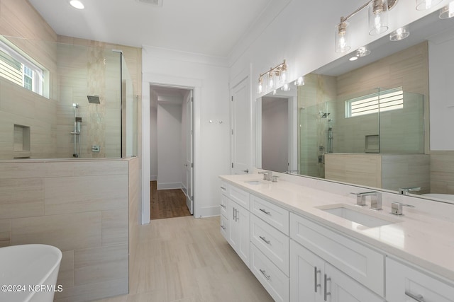 bathroom featuring vanity, crown molding, and separate shower and tub