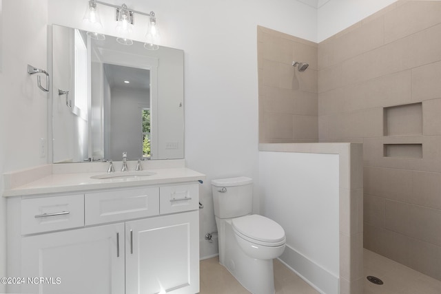 bathroom featuring vanity, tiled shower, and toilet