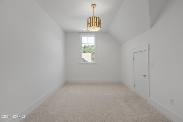 bonus room with vaulted ceiling and light colored carpet