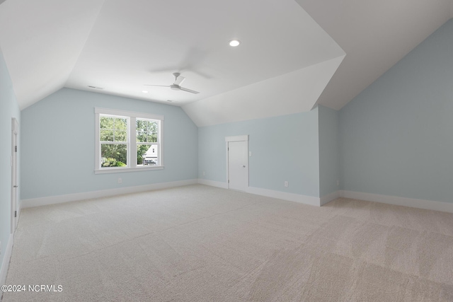 additional living space with vaulted ceiling, light colored carpet, and ceiling fan