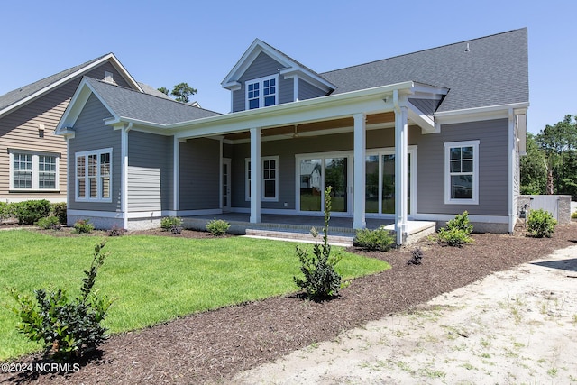 rear view of house with a porch and a yard