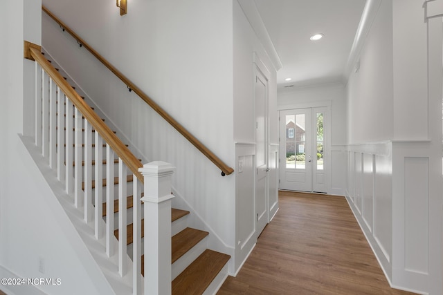 foyer with crown molding and light wood-type flooring