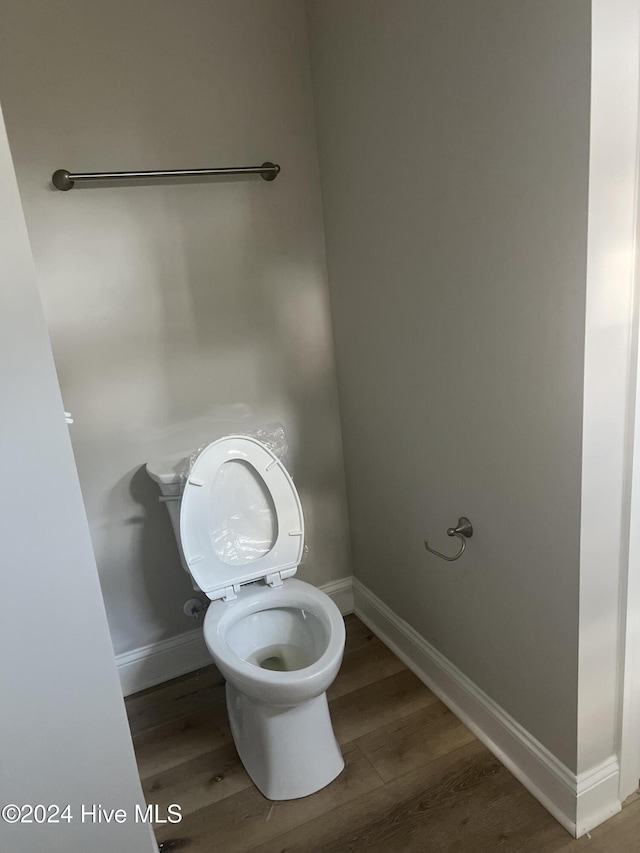 bathroom with toilet and hardwood / wood-style flooring