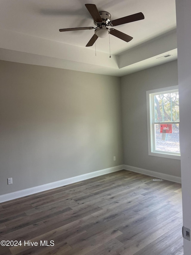 spare room with dark hardwood / wood-style flooring and ceiling fan