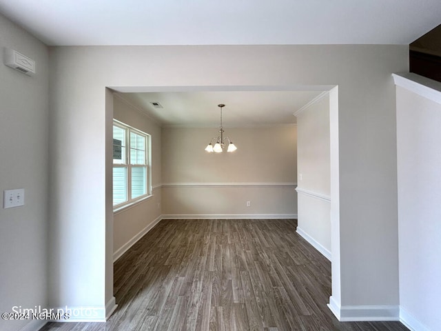 empty room with dark hardwood / wood-style floors and an inviting chandelier