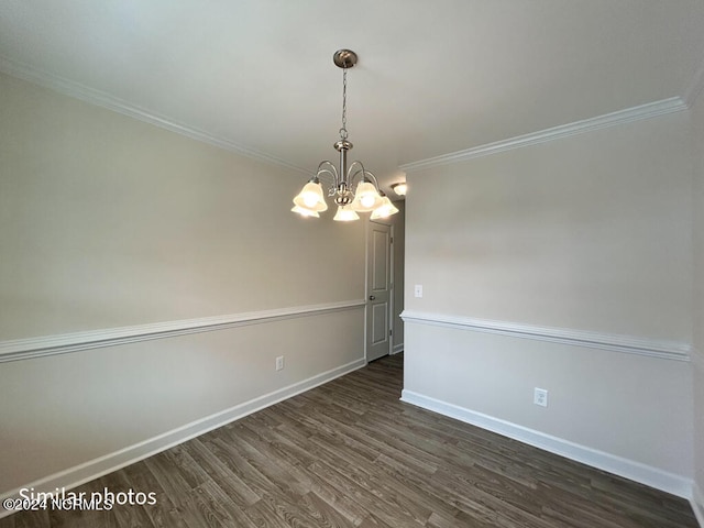 spare room with ornamental molding, dark hardwood / wood-style floors, and a chandelier