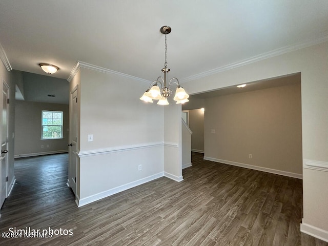 spare room featuring dark hardwood / wood-style floors, ornamental molding, and a chandelier