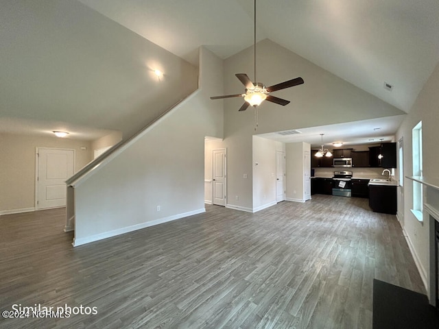 unfurnished living room with sink, hardwood / wood-style flooring, high vaulted ceiling, and ceiling fan with notable chandelier