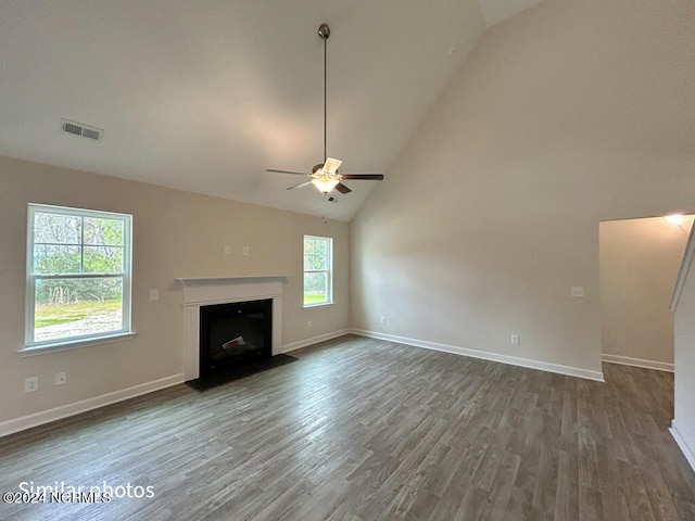 unfurnished living room with ceiling fan, dark wood-type flooring, and high vaulted ceiling